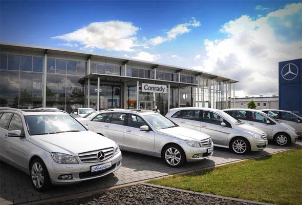 Das Autohaus in der Dieselstraße in Bitburg mit Glasfront, davor eine Reihe silberner und weißer Mercedes-Benz