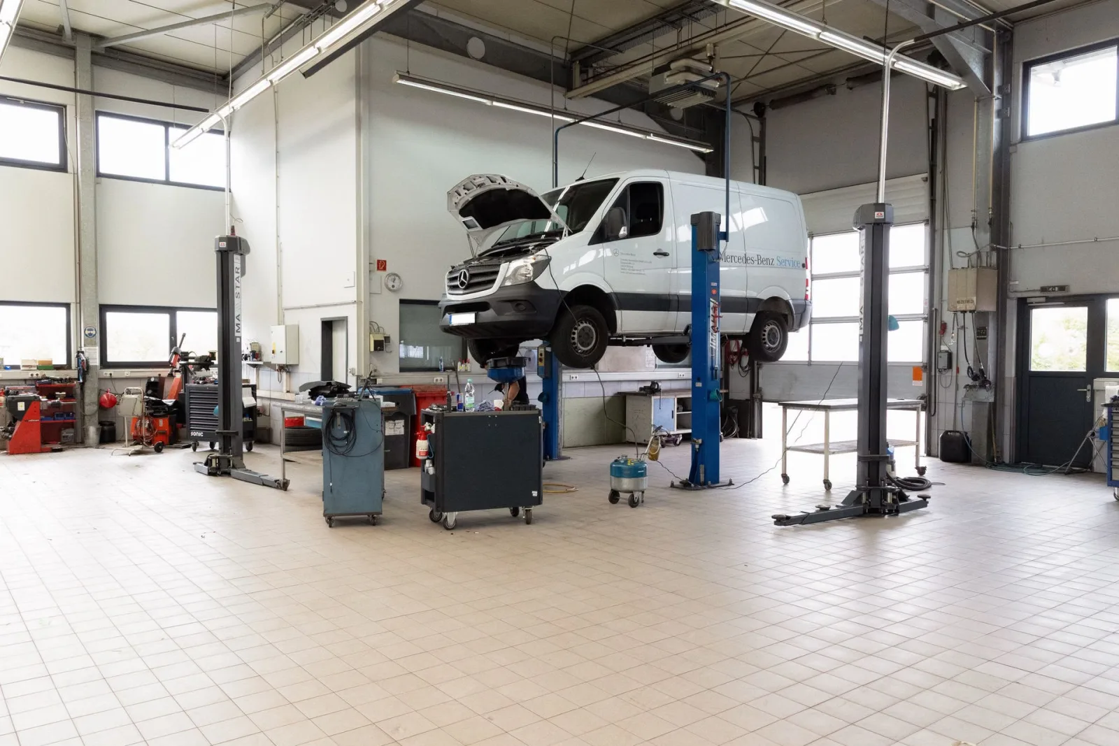 Weißer Mercedes-Benz Sprinter auf der Hebebühne in der Werkstatthalle von Conrady Automobile